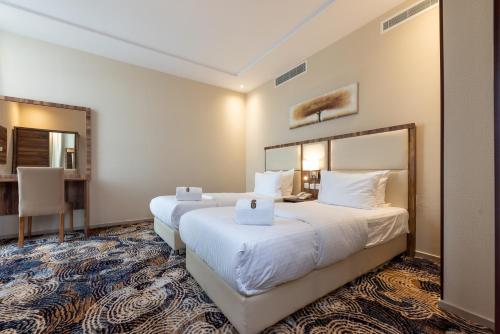Ένα ή περισσότερα κρεβάτια σε δωμάτιο στο GH HOTEL - فندق جي اتش