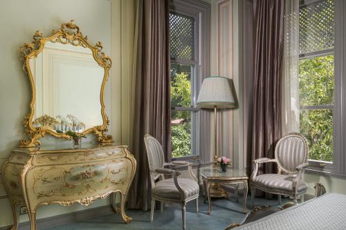 a bedroom with a dressing table and chairs and a mirror at Bosphorus Palace Hotel in Istanbul