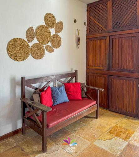 a bench with red and blue pillows in a room at Pousada Curva dos Ventos in Icaraí