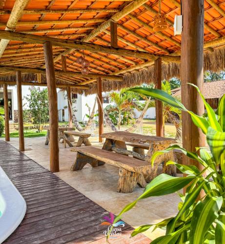 a pavilion with benches and hammocks on a deck at Pousada Curva dos Ventos in Icaraí