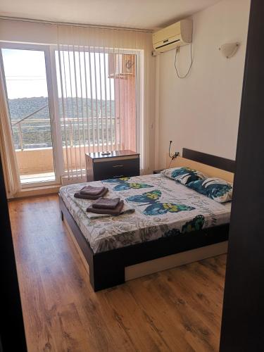 a bedroom with a bed and a large window at Seaview apartment complex Karia12 in Kavarna