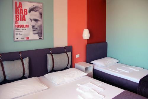 a room with two beds and a poster on the wall at I Registi in Scalea