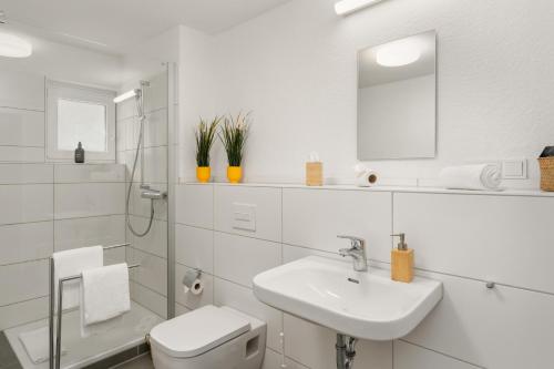 ein weißes Badezimmer mit Waschbecken und Toilette in der Unterkunft City Oase Bremen Zentrale Lage 300m zum Dom in Bremen