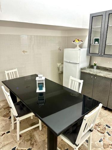 a kitchen with a black table with chairs and a refrigerator at Brezza Marina Apartments in Giardini Naxos