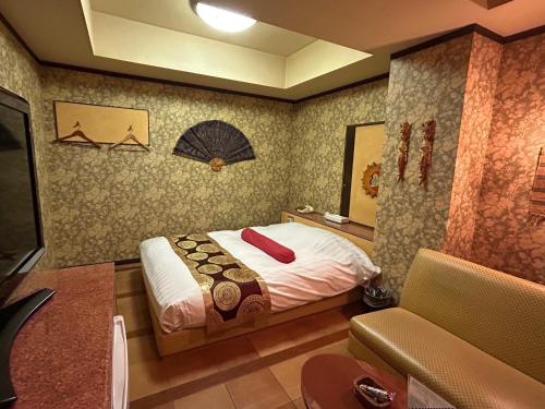 a bedroom with a bed and a couch in it at ホテルアイエス in Yokohama