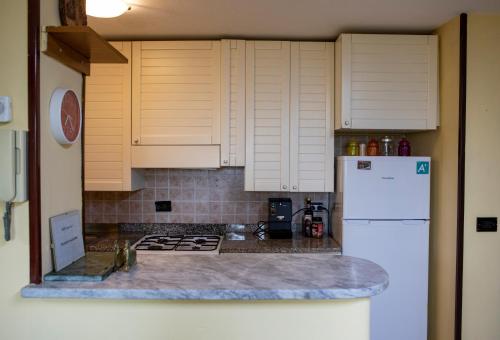 a kitchen with white cabinets and a white refrigerator at Casa Vacanze Diamante in Ogliastro Cilento