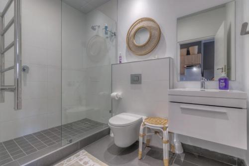 a bathroom with a toilet and a sink and a shower at Trebuchet Studio Apartment in Somerset West