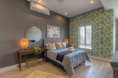 a bedroom with a bed and a mirror at Trebuchet Studio Apartment in Somerset West
