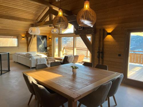 une salle à manger avec une grande table et des chaises en bois dans l'établissement Chalet Thena, Luxury - 8 personnes avec vue panoramique sur les montagnes, à La Bresse
