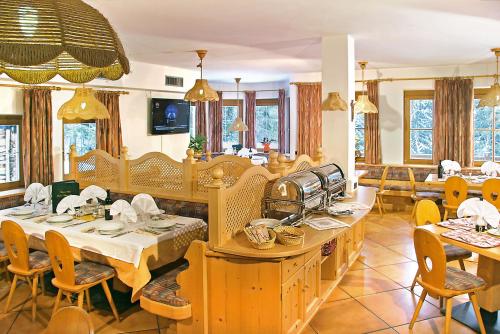 a restaurant with tables and chairs in a room at Hotel Villetta Maria Cottage in Canazei
