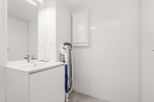 - une salle de bains blanche pourvue d'un lavabo et d'un radiateur dans l'établissement Cap d'Adge Suit'Appart 4 Saisons 27 M2 + 6 M2 Terrasse, au Cap d'Agde