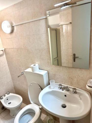 a bathroom with a white toilet and a sink at Brezza Marina Apartments in Giardini Naxos