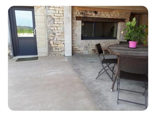 d'une terrasse avec une table et des chaises ainsi qu'une porte bleue. dans l'établissement sab, à Tarcenay