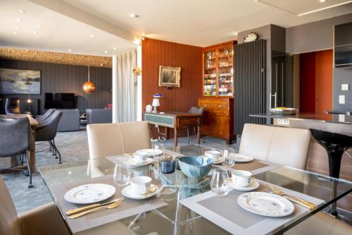 a dining room with a glass table and chairs at Zevende hemel in Zeebrugge