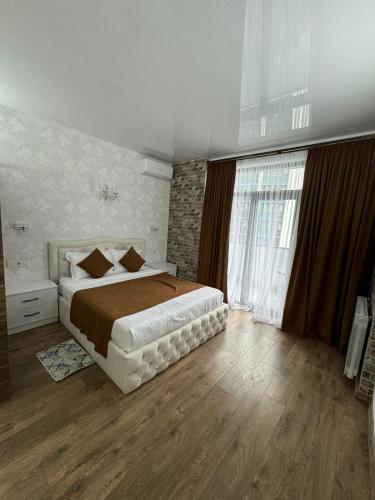a bedroom with a large bed and a large window at Moonlight Apart-Hotel Batumi in Batumi