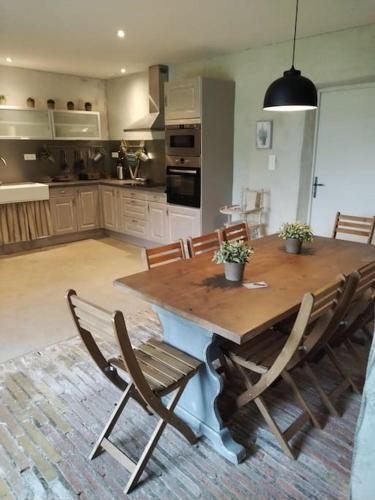 une cuisine avec une table en bois et quelques chaises dans l'établissement Manoir des Barrayrous, à Nègrepelisse