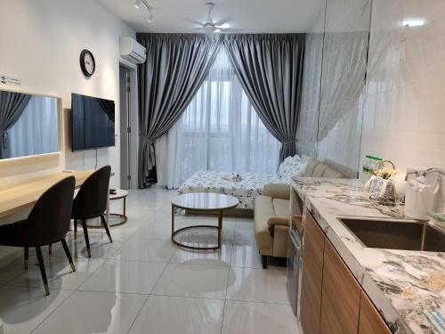 a kitchen and living room with a couch and a table at Sky Trees Apartment at Bukit Indah Johor in Johor Bahru