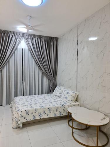 a small bedroom with a bed and a table at Sky Trees Apartment at Bukit Indah Johor in Johor Bahru