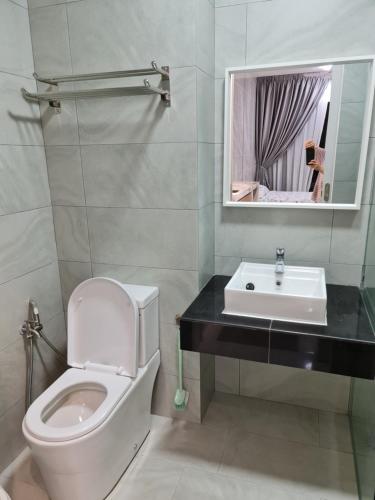 a bathroom with a toilet and a sink and a mirror at Sky Trees Apartment at Bukit Indah Johor in Johor Bahru