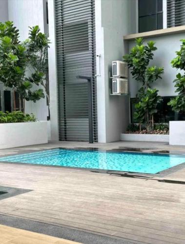 a swimming pool in front of a building at Sky Trees Apartment at Bukit Indah Johor in Johor Bahru