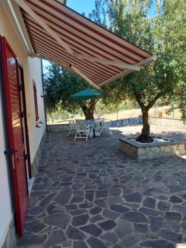 a patio with awning and a table and umbrella at Casa Vacanze Relax in Agropoli