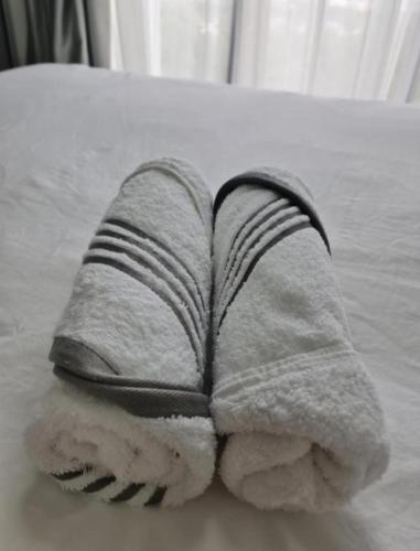 a folded towel sitting on top of a bed at Sky Trees Apartment at Bukit Indah Johor in Johor Bahru