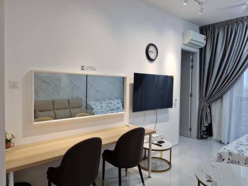 a living room with a desk and chairs and a tv at Sky Trees Apartment at Bukit Indah Johor in Johor Bahru