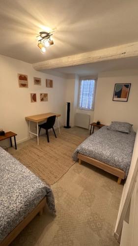 une chambre avec deux lits et une table dans l'établissement Appartement Cosy à Collobrières, à Collobrières