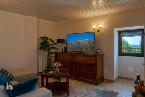 a living room with a flat screen tv and a couch at Casa do Fasco in Castro Laboreiro