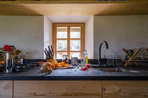 a kitchen with a sink and a counter top with food on it at The Poetic Chalet by Gryon Exclusive in Gryon