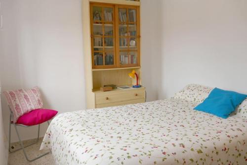a bedroom with a bed with a chair and a cabinet at Casa Soleada Calle Tranquila Junto a FIBES in Seville