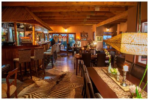 a restaurant with tables and chairs and a bar at Thali Thali Game Lodge in Langebaan