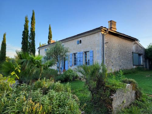 une ancienne maison en pierre dans un jardin arboré dans l'établissement Chez Foucherie, à Nonac