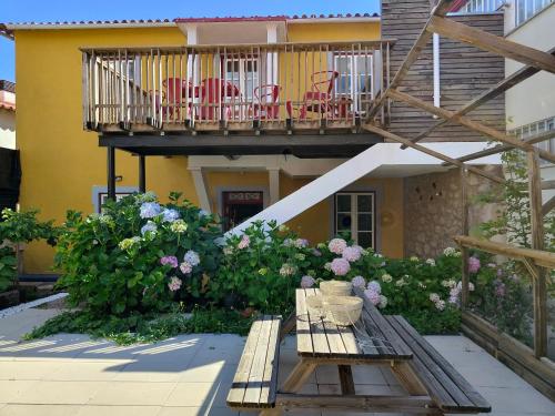 a balcony of a house with a bench and flowers at Urbe Sanchina - Hostel & Suites in Guarda