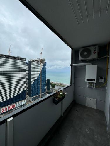 a room with a large window with a view of the ocean at Moonlight Apart-Hotel Batumi in Batumi
