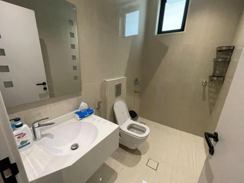 a bathroom with a white sink and a toilet at شقة فندقية فاخرة in Al Madinah