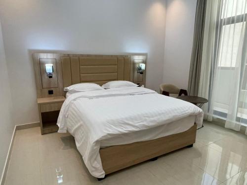 a bedroom with a large bed with white sheets and pillows at شقة فندقية فاخرة in Al Madinah