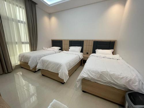 a bedroom with two beds and a window at شقة فندقية فاخرة in Al Madinah