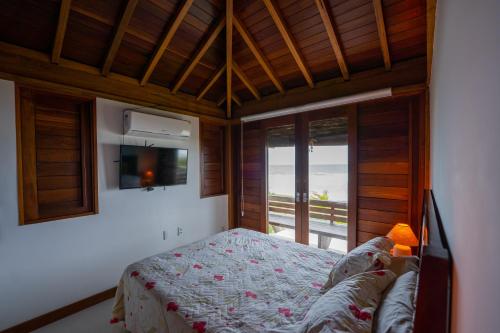 a bedroom with a bed and a tv and a window at Casa Paraíso Tropical Porto de Sauípe in Canoas