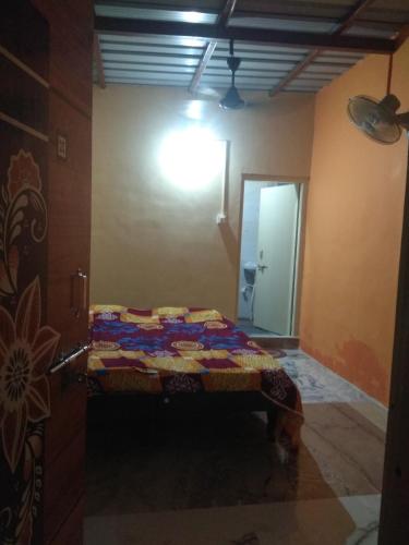 a room with a bed in the corner of a room at Ashok Home Stay in Hampi