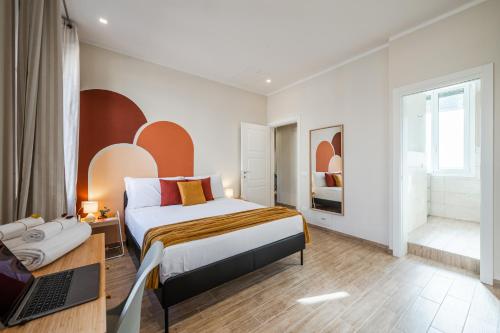 a bedroom with a bed and a laptop on a desk at Sui Tetti di Bologna centro, Casa Dei Colori in Bologna