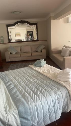 a large bed in a room with a couch and a mirror at Serenity in Coto