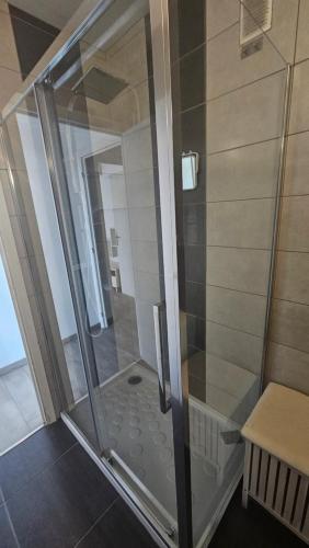 une douche avec une porte vitrée dans une salle de bain dans l'établissement Studio equipé vu sur mer proche centre ville, à Cagnes-sur-Mer
