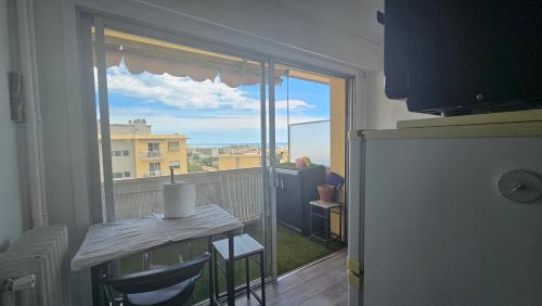 Cette chambre dispose d'un balcon avec une table et une fenêtre. dans l'établissement Studio equipé vu sur mer proche centre ville, à Cagnes-sur-Mer