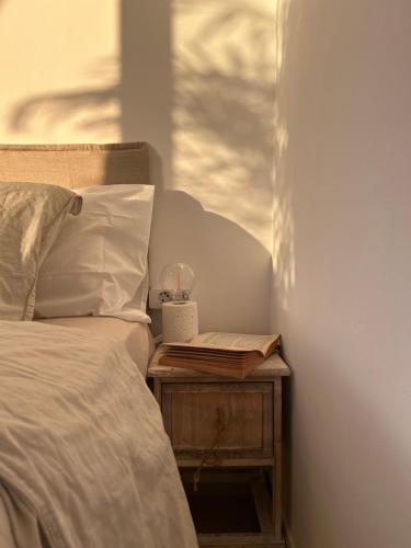 a bed with a book on a table next to a window at Sunset Oasis of Los Gigantes in Puerto de Santiago