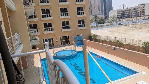 a view of a swimming pool from a balcony of a apartment at Lavender Oasis - Entire Spacious 1 flat in Jumeirah Village Circle in Dubai