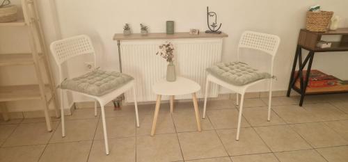 a room with three chairs and a table with a vase at The Holiday House in Mavráta
