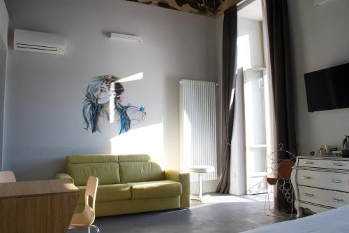 a living room with a green couch and a painting on the wall at Piazza Castello Suite in Turin