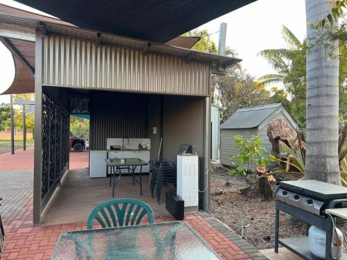 a patio with a table and chairs and a grill at Shauna's Shack in Katherine