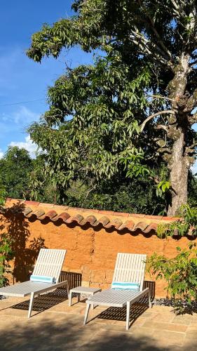 two white chairs sitting next to a brick wall at Terrazul Barichara in Barichara